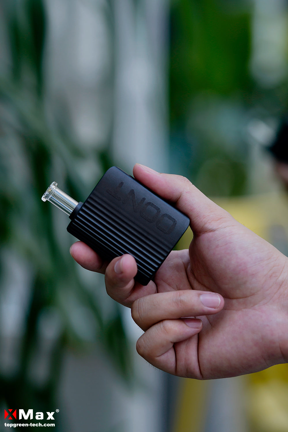 Kompakter XMAX OONT Vaporizer in der Hand, ideal für unterwegs mit ausziehbarem Glasmundstück und schnellem Reinigen – perfekt für trockene Kräuter.