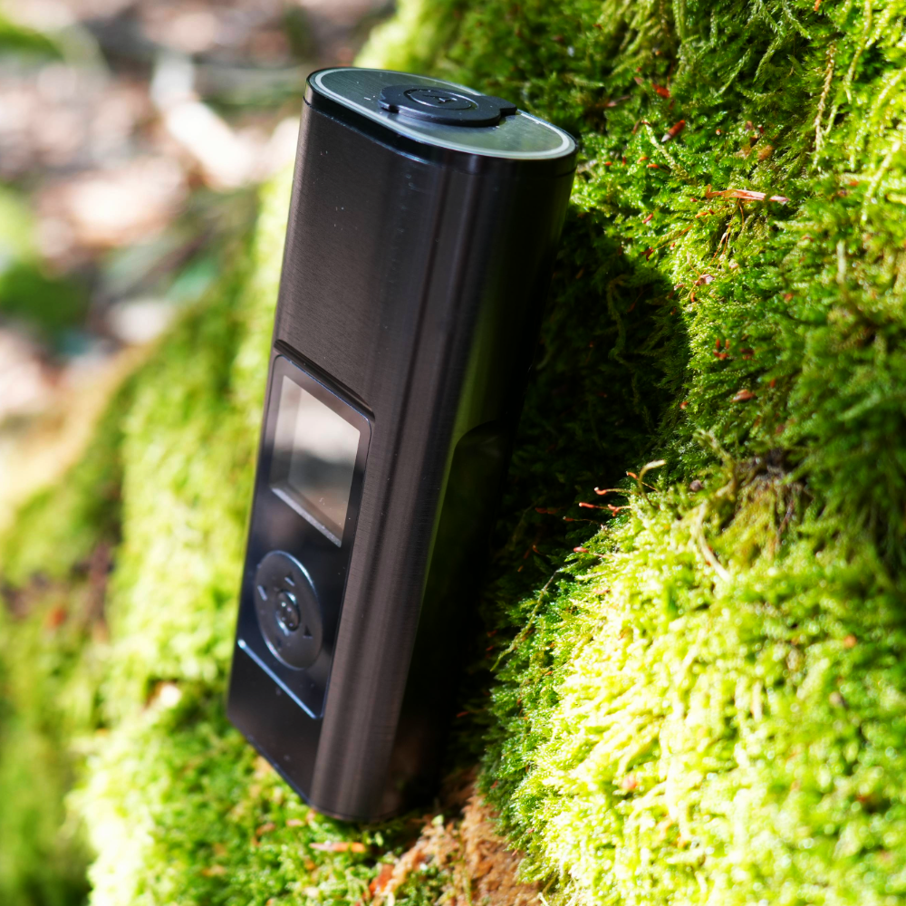 Schwarz glänzender Arizer Solo 3 V2 aus seitlicher Perspektive auf einem moosigen Baum im Wald fotografiert