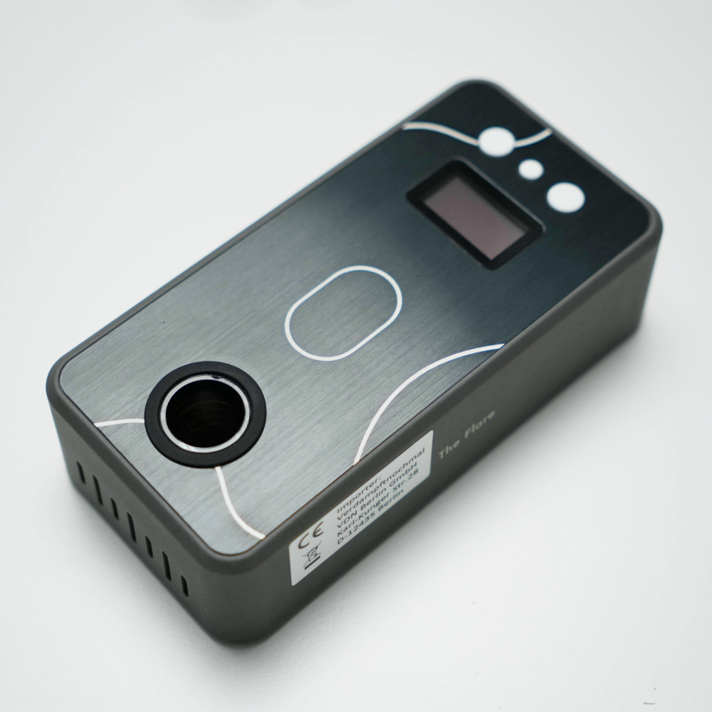 Schrägansicht des Battery-Free Ganz Flare V2 mit Display, Bedienknöpfen und runder Heizöffnung auf gebürsteter Metalloberfläche