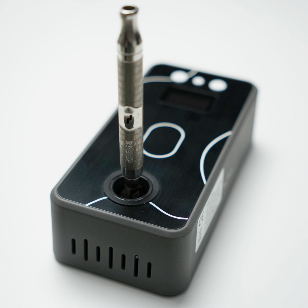 Battery-Free Ganz Flare V2 Induktionsheizer mit eingesetztem DynaVap VapCap aus Edelstahl auf schwarzer Oberseite